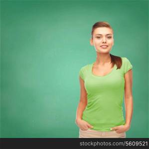 education, t-shirt design and people concept - smiling young woman in blank green t-shirt