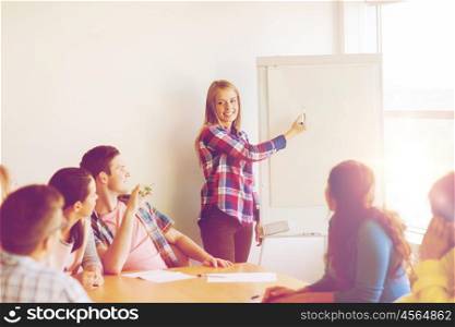 education, teamwork, learning and people concept - group of smiling students with flip board