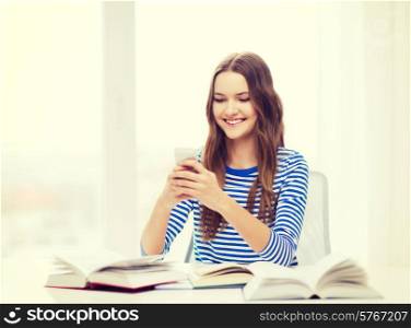 education, technology and home concept - happy smiling student girl with smartphone and books