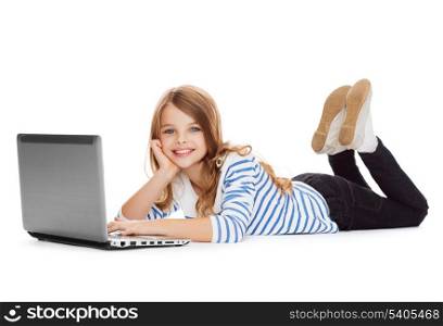 education, technology and internet concept - smiling little student girl with laptop computer lying on the floor