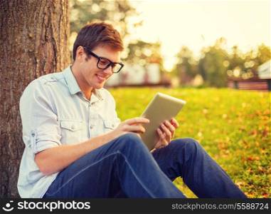 education, technology and internet concept - smiling male student in eyeglasses with tablet pc outside