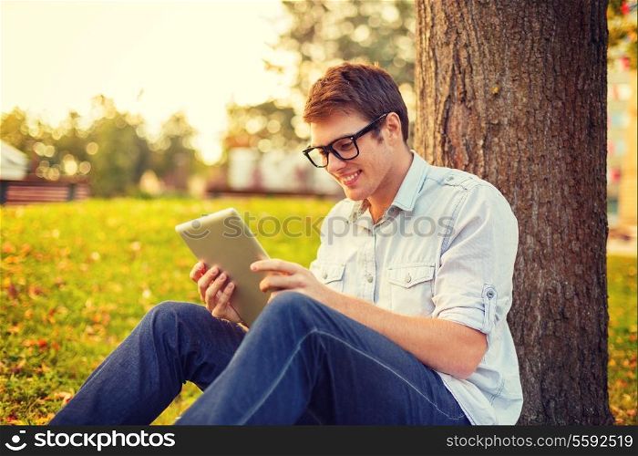 education, technology and internet concept - smiling male student in eyeglasses with tablet pc outside