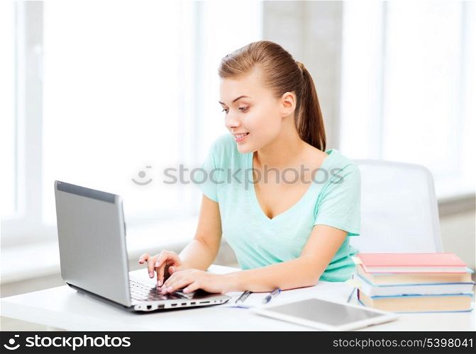 education, technology and internet concept - smiling student girl with laptop