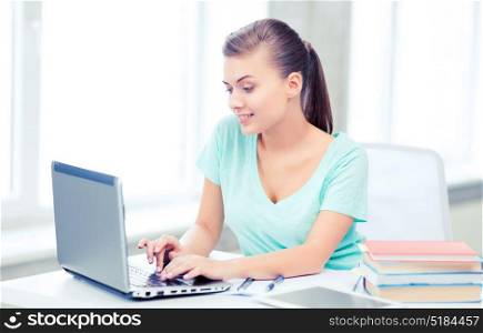 education, technology and internet concept - smiling student girl with laptop. smiling student girl with laptop