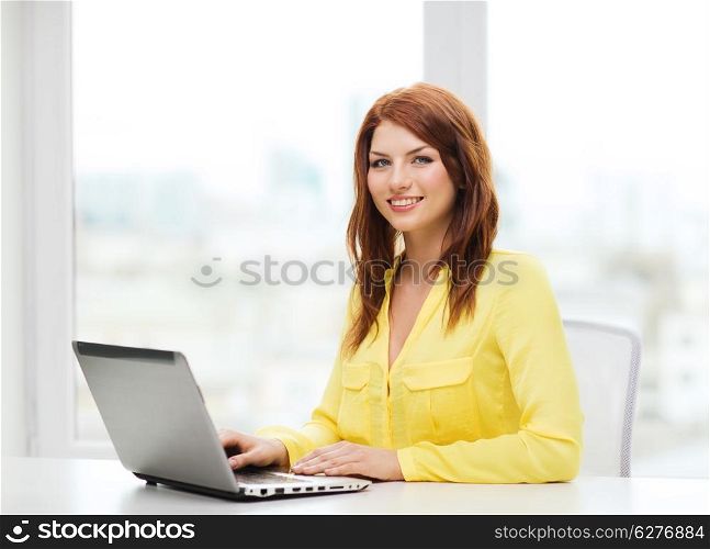 education, technology and internet concept - smiling student with laptop computer at school
