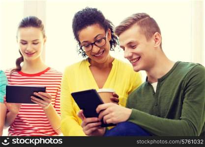 education, technology and internet concept - smiling students looking at tablet pc computer at school