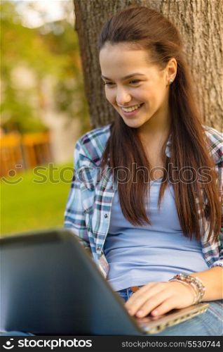 education, technology and internet concept - smiling teenager with laptop computer