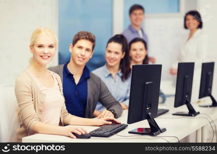 education, technology and internet concept - students looking at computer monitor at school