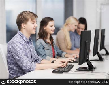 education, technology and internet concept - students looking at computer monitor at school