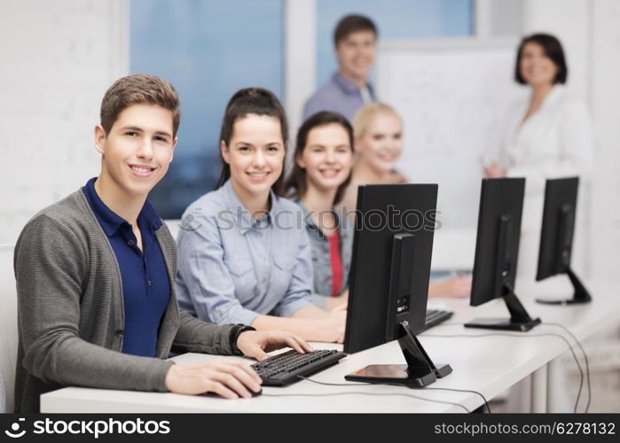 education, technology and internet concept - students with computer monitor at school