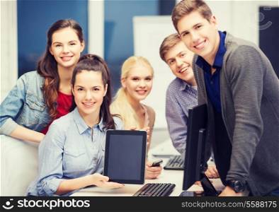 education, technology and internet concept - students with monitor and blank tablet pc screen