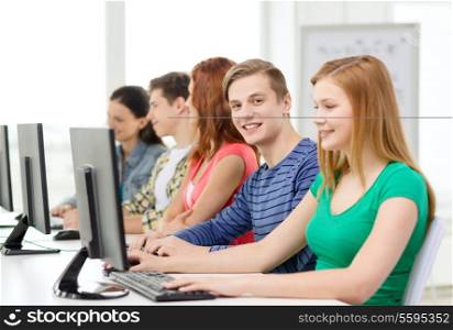 education, technology and internet - smiling male student with computer studying at school