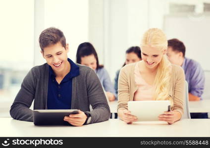 education, technology and internet - two smiling students looking at tablet pc in lecture at school