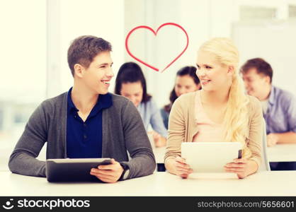 education, technology and internet - two smiling students looking at tablet pc in lecture at school