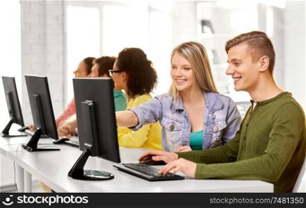education, technology and learning concept - group of happy international high school students or classmates in computer class. happy high school students in computer class