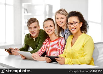 education, technology and learning concept - group of happy international high school students or classmates with tablet pc computers. high school students with tablet computers