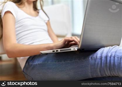 education, technology and people concept - close up of teenage student girl with laptop and books at home. teenage student girl with laptop and books at home