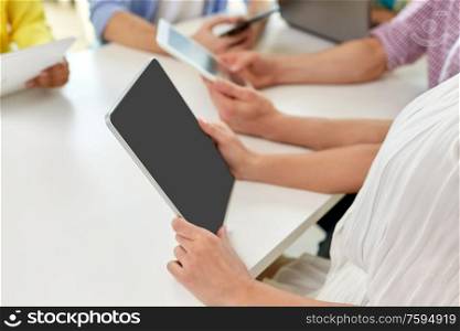 education, technology and people concept - group of high school students or classmates with tablet pc computers at table. group of high school students with tablet pc