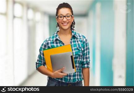 education, technology and people concept - smile female african american student in eyeglasses with folders and tablet pc