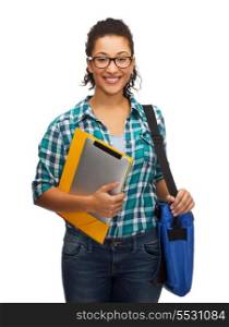 education, technology and people concept - smiling female african american student in eyeglasses with folders, bag and tablet pc