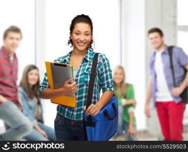 education, technology and people concept - smiling female african american student with folders, bag and tablet pc