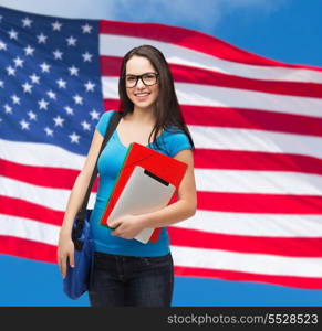 education, technology and people concept - smiling student in black glasses with bag, folders and tablet over american flag background