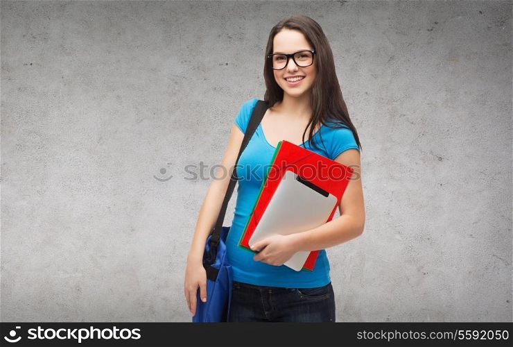 education, technology and people concept - smiling student wearing black eyeglasses with bag, folders and tablet pc computer standing