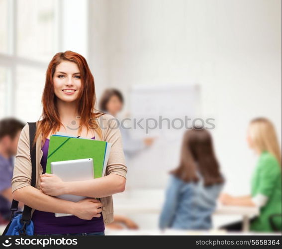 education, technology and people concept - smiling student with bag, folders and tablet pc computer standing in class