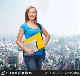 education, technology and people concept - smiling student with bag, folders and tablet pc computer standing