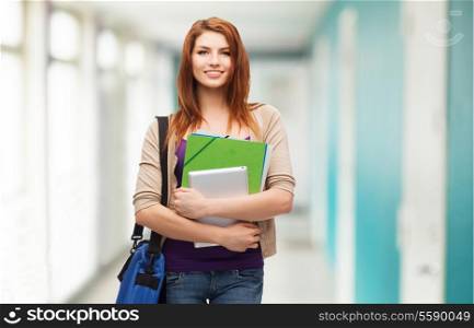 education, technology and people concept - smiling student with bag, folders and tablet pc computer standing