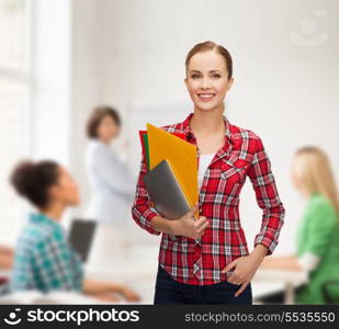 education, technology and people concept - smiling student with folders and tablet pc computer