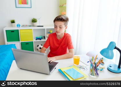 education, technology and people concept - student boy typing on laptop computer at home. student boy typing on laptop computer at home