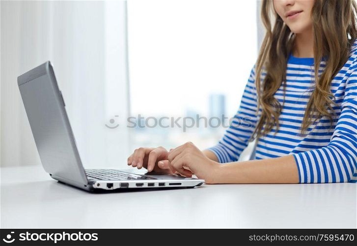 education, technology and people concept - student girl typing on laptop computer. student girl typing on laptop computer
