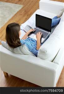 education, technology and people concept - teenage student girl with laptop and books at home. teenage student girl with laptop and books at home
