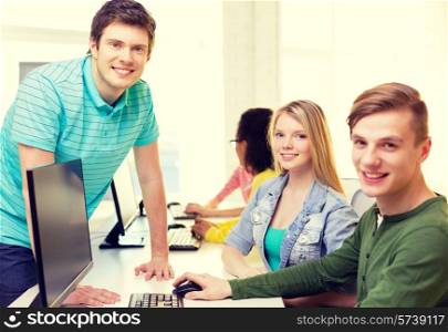 education, technology and school concept - group of smiling students in computer class