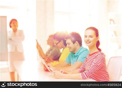 education, technology and school concept - smiling male student with classmates in computer class with teacher
