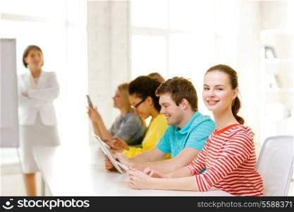 education, technology and school concept - smiling male student with classmates in computer class with teacher