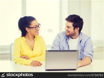 education, technology, business, startup and office concept - two smiling people with laptop in office