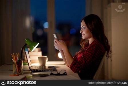 education, technology, communication, overwork and people concept - tired woman or student girl with smartphone and laptop computer at night home. student woman with laptop and smartphone at home. student woman with laptop and smartphone at home