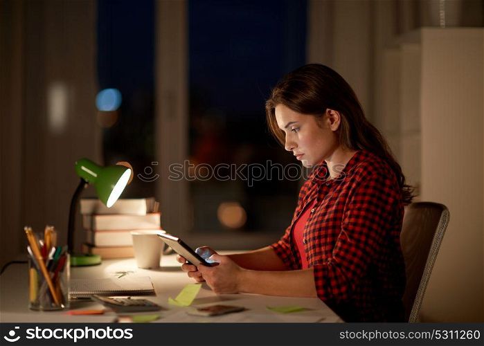 education, technology, freelance, overwork and people concept - woman or student girl with tablet pc computer at night home. student girl or woman with tablet pc at night home
