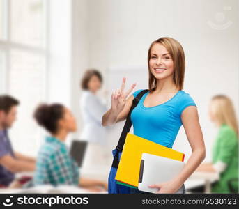 education, technology, gesture and people concept - smiling female student with bag, tablet pc computer and folders showing victory gesture