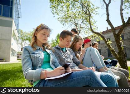 education, technology, internet addiction and people concept - group of students with smartphone and notebooks