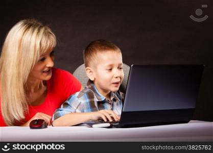 education, technology, internet and parenting concept - boy and mother with laptop computer