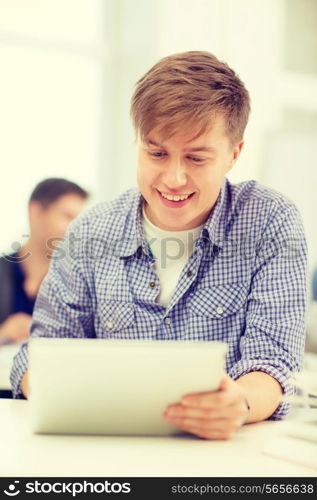 education, technology, internet and school concept - smiling teenage boy student with tablet pc computer at school