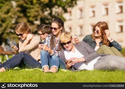 education, technology, internet, summer holidays, social networking and teenage concept - group of teenagers with smartphones