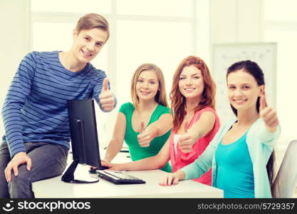 education, technology, school and people concept - group of smiling students showing thumbs up in computer class at school