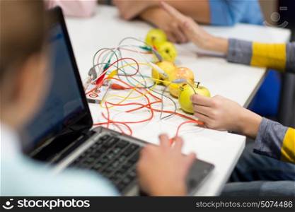 education, technology, science, programming and people concept - kids with invention kit and laptop at robotics school. kids, invention kit and laptop at robotics school