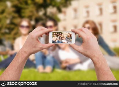 education, technology, summer holidays and teenage concept - close up of hands making picture of group of teens