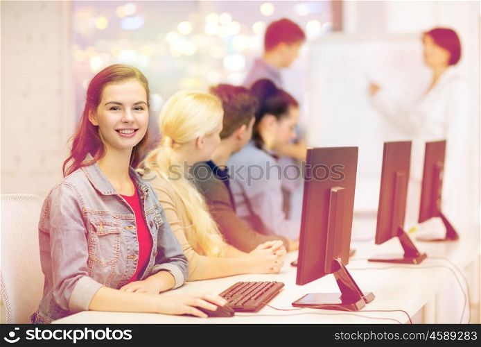 education, techology, school and internet concept - smiling teenage girl in computer class with classmates and teacher