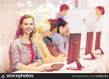 education, techology, school and internet concept - smiling teenage girl in computer class with classmates and teacher